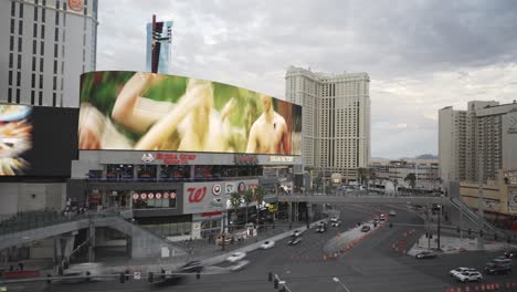 Time-lapse-of-big-large-LED-Billboard-wall-in-the-center-of-Las-Vegas-Nevada-marketing-ads-along-car-traffic-and-traffic-lights-at-day