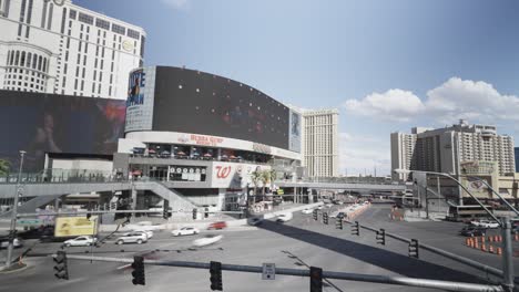 Lapso-De-Tiempo-De-Grandes-Paredes-De-Vallas-Publicitarias-En-El-Centro-De-Las-Vegas-Nevada-Anuncios-De-Marketing-A-Lo-Largo-Del-Tráfico-De-Automóviles-Y-Semáforos-Durante-El-Día-Y-En-ángulo-Bajo