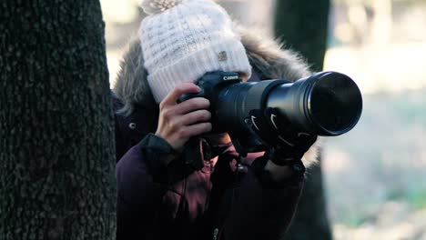 Close-up-shot-of-a-wildlife-photographer-using-a-Canon-camera