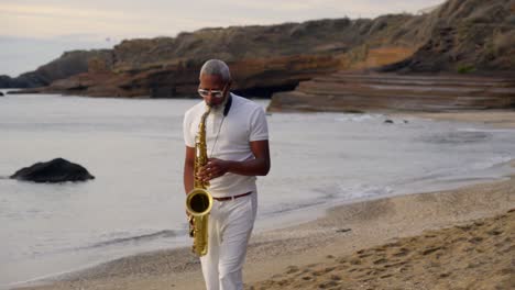 Toma-Lenta-Y-Reveladora-De-Un-Hombre-Tocando-El-Saxofón-En-La-Playa-Al-Atardecer.