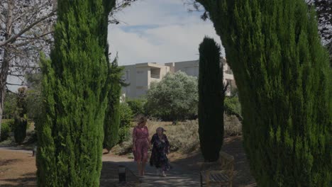 Toma-En-Cámara-Lenta-De-Una-Anciana-Caminando-Con-Su-Hija-En-Un-Jardín