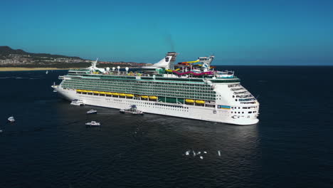 Aerial-view-rising-toward-the-Navigator-of-the-seas-voyager,-in-sunny-Cabo,-Mexico