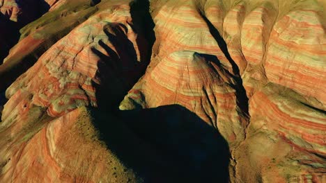 Aerial-view-Petra,-Jordan,-Middle-East-Dhol-camera-moving-upwards-where-the-mountains-are-glowing-with-sunlight