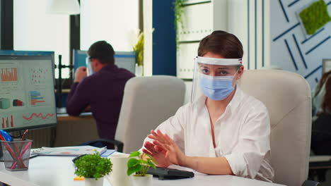 Businesswoman-with-visor-and-mask-talking-in-front-of-camera