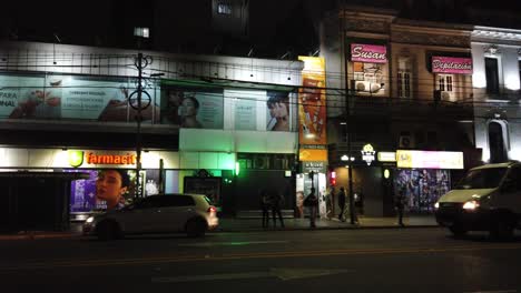 Buenos-Aires-City-at-night,-Streets-of-Caballito-Neighborhood-Neon-Signs,-People-Walking-By