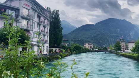 Interlaken,-Suiza,-Turismo-De-Inmersión,-Ciudad-Turística-En-El-Valle-De-La-Montaña,-Europa,-Caminar,-Día-Lluvioso,-4k-|-Mirando-A-Su-Alrededor,-Tembloroso,-Agua,-Río,-Lago,-Restaurante,-Hotel,-Flores,-Arboles,-Distancia