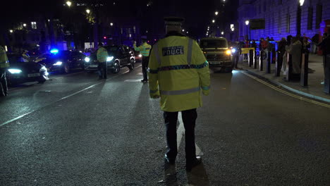 Polizisten-Der-Stadtpolizei-Stehen-An-Einer-Straßenkreuzung-Auf-Dem-Parlamentsplatz-Und-Weisen-Nachts-Fahrzeuge-Aus-Dem-Gebiet-Weg