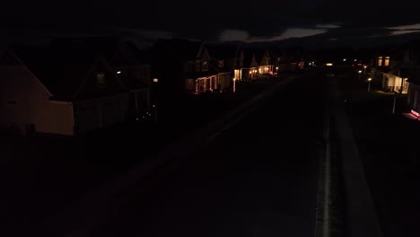 FedEx-delivery-truck-driving-through-large-neighborhood-at-night-in-USA