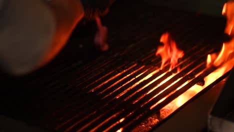 Preparando-Una-Parrilla-De-Barbacoa-Sobre-Fuego-Chisporroteante-En-Cámara-Lenta-Por-El-Chef-En-Un-Restaurante-De-Alta-Gama