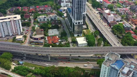 Vista-Aérea,-Toma-Inclinada-Hacia-Arriba-Que-Captura-El-Complejo-Sistema-De-Transporte-Interconectado-En-Seputeh,-Kuala-Lumpur,-Malasia,-Y-La-Autopista-Lebuhraya-Persekutuan-Que-Conduce-A-Klang-Con-Una-Fuerte-Contaminación-Del-Aire