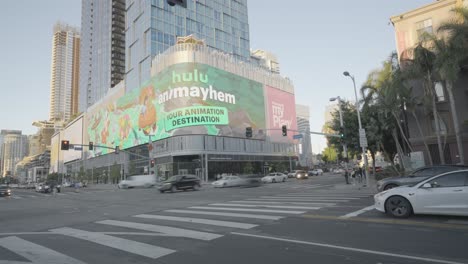 Motion-lapse-of-big-large-LED-Billboard-walls-in-downtown-Los-Angeles-california-showing-marketing-ads-along-car-traffic-and-traffic-lights-at-day-time
