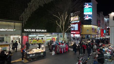 La-Gente-Visita-El-Mercado-Nocturno-Del-Distrito-Comercial-De-Myeongdong-Y-Los-Puestos-De-Comida-Callejera-En-Seúl.