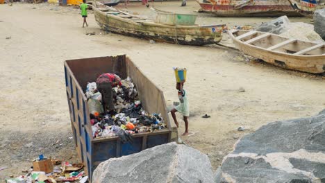 El-Hombre-Mira-A-Través-De-La-Basura-En-El-Contenedor-De-Basura-Junto-Al-Puerto-Pesquero-De-Ghana,-Amplia