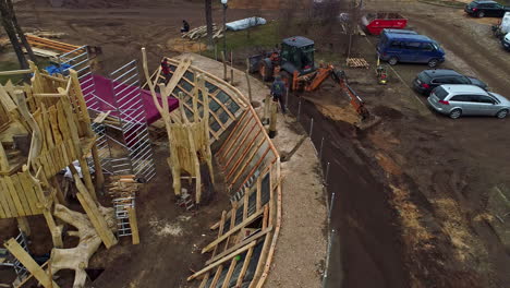 Construction-of-a-city-park-with-wooden-playground-fort-and-landscaping---aerial-reveal