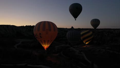 Vista-Aérea-De-Pavo-En-Capadocia-Cámara-De-Drones-En-Globo-Aerostático-Moviéndose-De-Adelante-Hacia-Atrás-Donde-Vuelan-Los-Globos