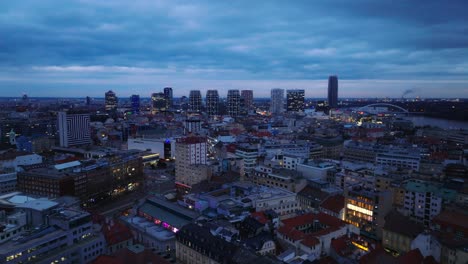 Vista-Aérea-Por-Drones-De-La-Ciudad-Vieja-Y-Del-Centro-De-Bratislava-Con-Modernos-Edificios-Comerciales-Por-La-Noche