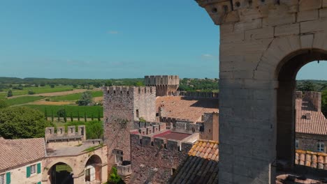 Aerial-view-of-french-architectural-castle,-exterior-view,-hill-landscape-in-the-background-in-medieval-village