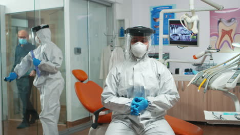 Dentist-with-coverall-looking-at-camera-talking-with-patients