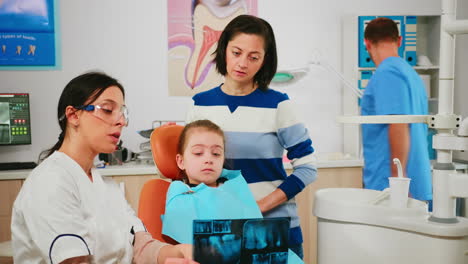 Kinderzahnarzt-Zeigt-Zahnprobleme-Mit-Röntgenbild