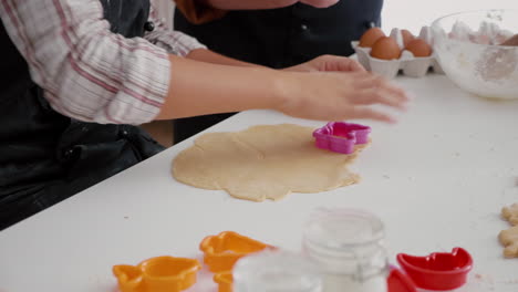 Granddaughter-whit-grandmother-preparing-delicious-gingerbread-dessert-using-cooking-shape