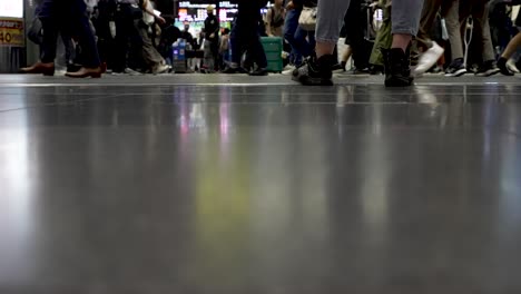 Hora-Punta-En-La-Estación-De-Tren-De-Kioto,-Pies-Y-Piernas-De-Los-Pasajeros-Del-Tren-Y-Reflejo-De-La-Sombra-En-La-Superficie-Del-Suelo