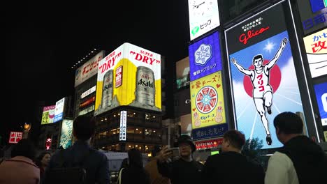 Das-Berühmte-Glico-Mann-Schild-Ist-Nachts-Beleuchtet-Und-Touristen-Fotografieren