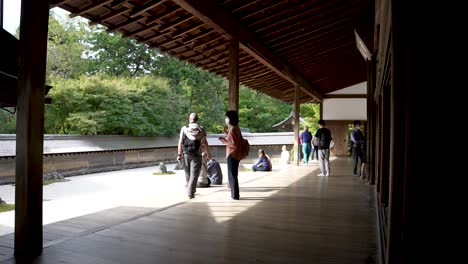 Tourists-Admiring-View-Of-Ryoanji-Temple-Zen-Rock-Garden-In-The-Morning-From-Veranda