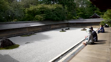 Touristen-Sitzen-Morgens-Auf-Der-Veranda-Und-Bewundern-Die-Ryoanji-Tempel-Und-Den-Zen-Steingarten