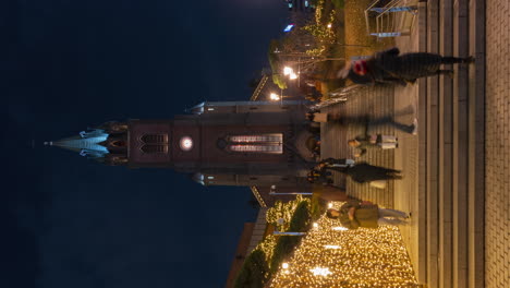 Lapso-Nocturno-De-La-Catedral-De-Myeongdong---Gente-Subiendo-Y-Bajando-Las-Escaleras-Disfrutando-Del-Espíritu-Navideño-Y-La-Espectacular-Decoración-De-Guirnaldas-Brillantes---Acercamiento-Vertical