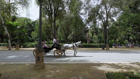 Turistas-En-Carruaje-Tirado-Por-Caballos-Recorriendo-La-Plaza-De-España-En-Sevilla,-España