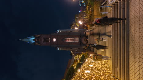 Vertical-shot-of-Myeongdong-Cathedral-Night-Time-Lapse---People-Walking-up-and-down-the-Steps-Enjoying-Christmas-Spirit-And-Spectacular-Glowing-Garlands-Decoration