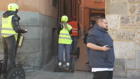 Touristen-Nutzen-Segways,-Um-Die-Engen-Gassen-Der-Innenstadt-Zu-Durchsuchen