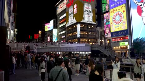 Crowded-street-of-Dotonbori-at-night,-Illuminated-signboards-at-Ebisu-Bridge-on-the-Dōtonbori-Canal