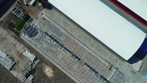 Aerial-drone-bird's-eye-view-over-under-construction-new-storage-facility-in-a-Industrial-zone-at-daytime