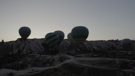 Aerial-view-turkey-in-Cappadocia-hot-air-balloon-descending-on-tourists