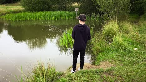 An-Einem-Trüben-Sommertag-Stand-Ein-Kleiner-Junge-Allein-Am-Ufer-Des-Sees-Und-Fischte