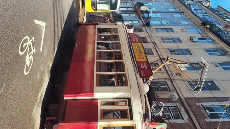 01-December-2023-Lisabon,-Portugal:-Tram-on-a-Street-With-Decorated-Colorful-Houses-in-Christmas-Time