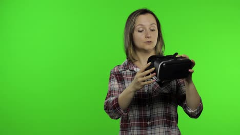 Young-woman-using-VR-headset-helmet-to-play-game,-showing-side-advertising-area.-Chroma-key