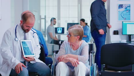 Doctor-explaining-diagnosis-to-elderly-woman-in-wheelchair