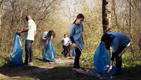 Mom-and-child-collecting-rubbish-from-the-forest-area-using-a-long-claw-tool