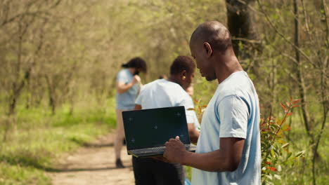 African-american-man-looks-at-mockup-screen-on-laptop