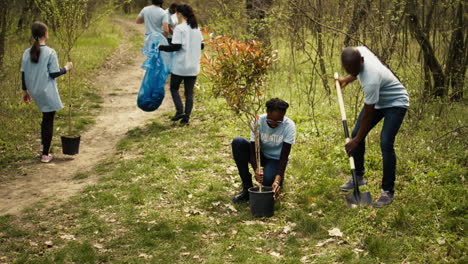 Ein-Team-Afrikanischer-Amerikanischer-Freiwilliger-Gräbt-Löcher-Und-Pflanzt-Bäume-In-Einem-Wald