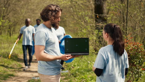 Equipo-De-Activistas-Del-Clima-Y-La-Naturaleza-Usando-Una-Computadora-Portátil-Con-Pantalla-Verde-Cerca-De-Un-Bosque