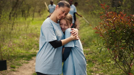 Portrait-of-mother-and-daughter-volunteering-to-clean-up-a-forest-area