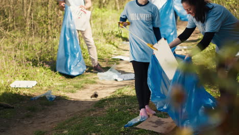 Mother-and-daughter-cleaning-up-the-woods-with-proper-tools-and-trash-bags