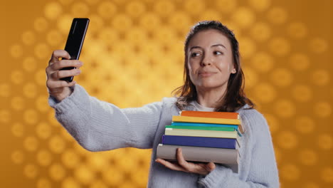 Señora-Alegre-Con-Un-Montón-De-Novelas-En-Brazos-Haciendo-Selfies,-Fondo-De-Estudio