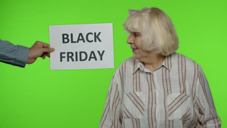 Inscription-advertising-Black-Friday-appears-next-to-joyful-grandmother-with-shopping-bags