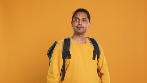 Retrato-De-Un-Hombre-Confiado-Con-Mochila-Térmica-Cruzando-Los-Brazos,-Fondo-De-Estudio