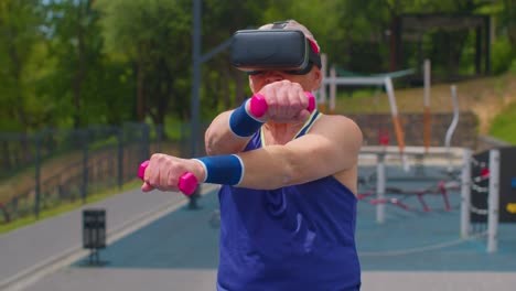 Älterer-Mann-Großvater-In-VR-Headset-Macht-Sporttraining-Fitness-Stretching-Übungen-Mit-Hanteln