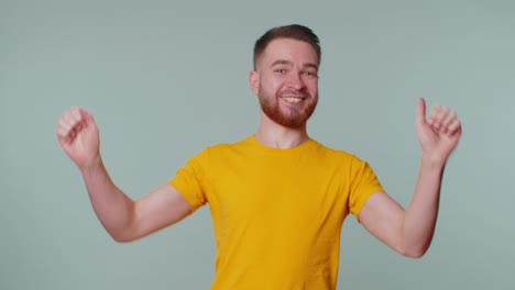 Stylish-man-in-t-shirt-shouting,-raising-fists-in-gesture-I-did-it,-celebrating-success,-winning